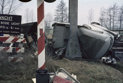 117435 Afbeelding van een verongelukte auto op een met AKI's beveiligde spoorwegovergang in de Nieuwe Weteringseweg ...